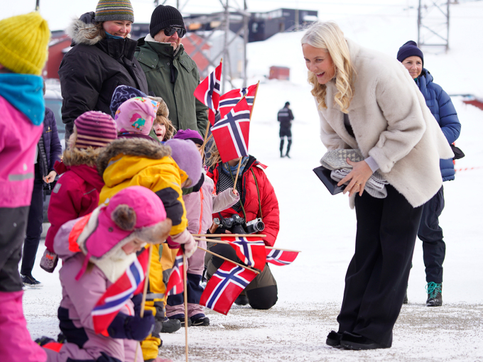 Kronprinsessen hilser på noen av barna som møtte Kronprinsparet utenfor Longyearbyen folkebibliotek. Foto: Ole Berg-Rusten / NTB